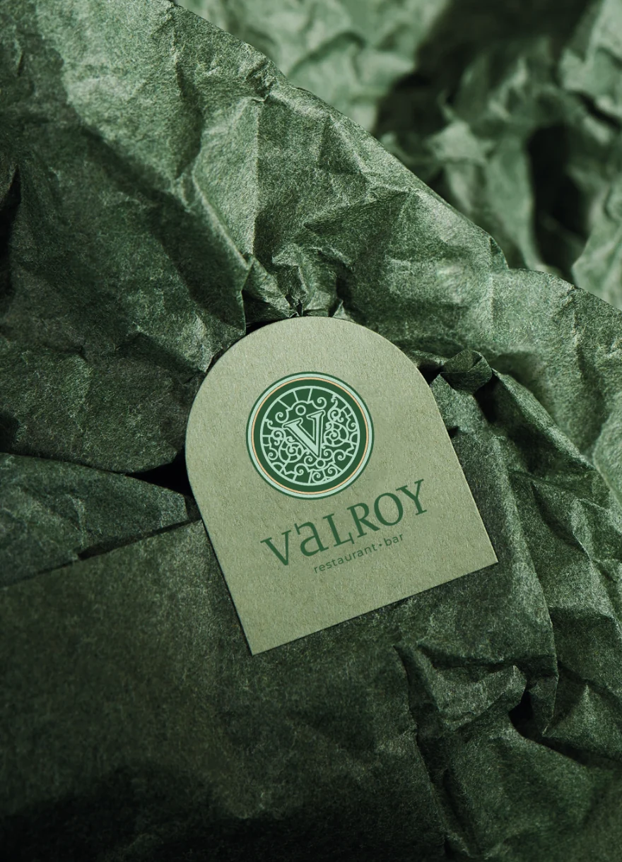 VALROY identity, an arched label and green tissue